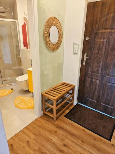 a bathroom with a toilet and a wooden door at Apartamenty pod Aniołami in Ostrów Wielkopolski