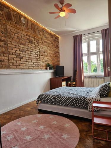 a bedroom with a bed and a brick wall at Apartamenty pod Aniołami in Ostrów Wielkopolski