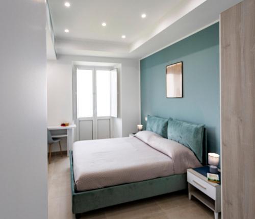 una camera da letto con un letto e una parete blu di B&B Bellaria Rooms a Longbardi