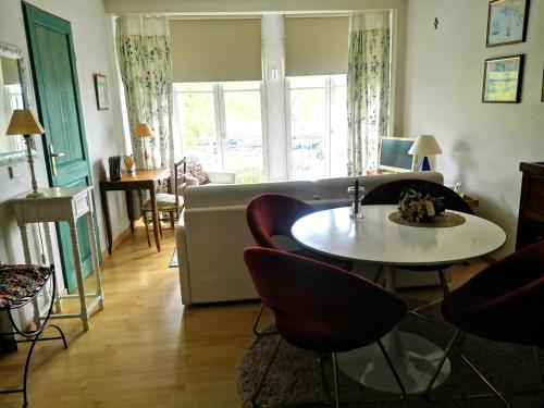 un salon avec une table, des chaises et un canapé dans l'établissement At the Balconies on the Digue Chic T3 for 2 to 4p baby with garage, à Honfleur