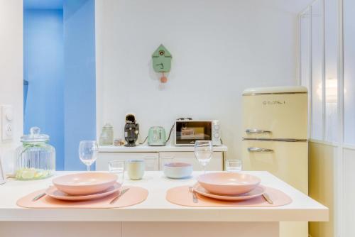 une cuisine avec deux assiettes et des verres sur un comptoir dans l'établissement La Confiserie - Lumineux - Atypique, à Douai