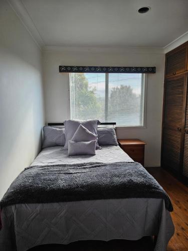 a bedroom with a large bed with a window at Beach House-Town House in Eden