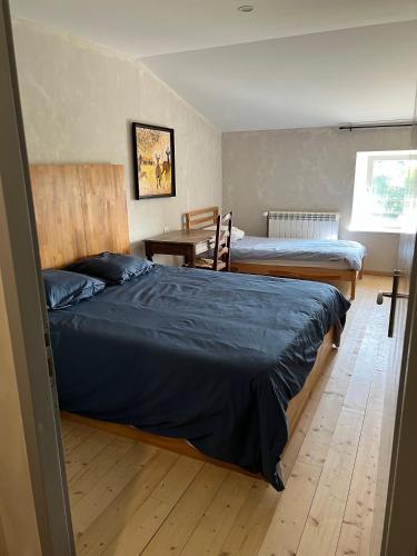 une chambre avec deux lits, une table et un bureau dans l'établissement Au point du jour Ch1, à Récourt-le-Creux