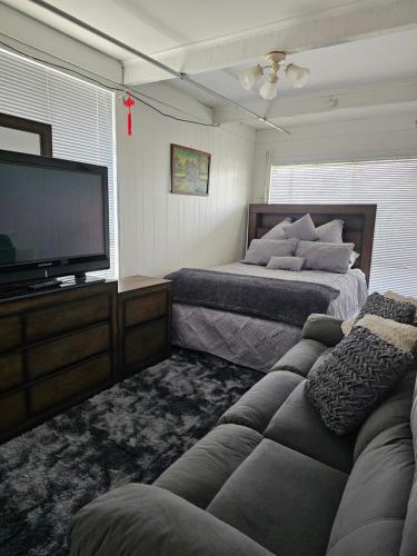 a living room with two beds and a flat screen tv at Beach House-Town House in Eden