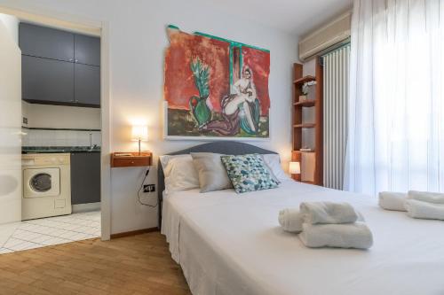 Un dormitorio con una cama blanca y un cuadro en la pared. en Italian Experience- Fano Lighthouse, en Fano