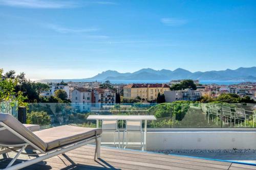 un balcon avec une table et une vue sur une ville dans l'établissement Sumptuous terrace apartment - Cannes - Sea view, à Cannes