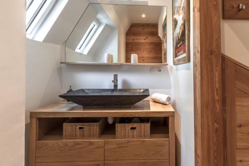 une salle de bain avec un lavabo noir et des puits de lumière dans l'établissement Le Chardonnet, à Sallanches