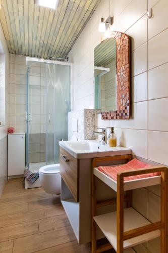a bathroom with a sink and a toilet and a mirror at Apartment Ina in Bled