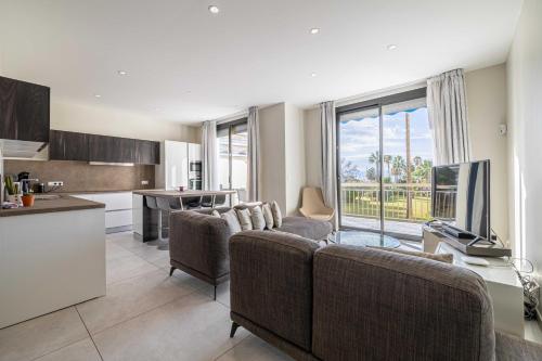 un salon avec un canapé et une télévision et une cuisine dans l'établissement Splendid apartment, Sea view, Parking - Croisette, à Cannes