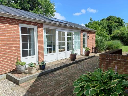 a house with a conservatory with potted plants at Kristinebjerg in Jelling