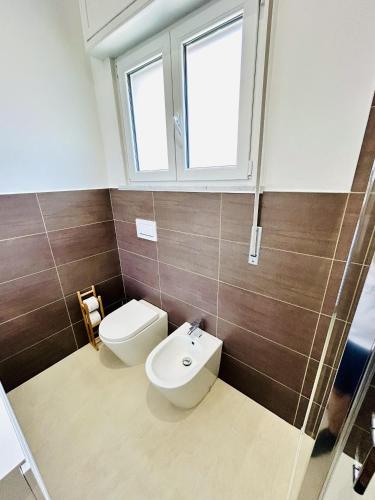 a bathroom with a toilet and a sink and a window at Camera Matrimoniale con bagno privato esterno in Casa Malpensa 89 in Samarate