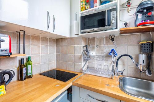 un comptoir de cuisine avec un évier et un micro-ondes dans l'établissement GuestReady - Beau Séjour au cœur de Paris, à Paris