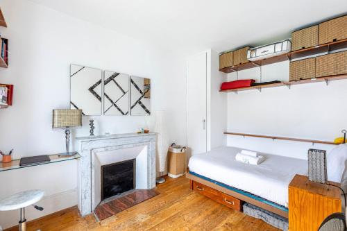 Cette chambre comprend un lit et une cheminée. dans l'établissement GuestReady - Beau Séjour au cœur de Paris, à Paris