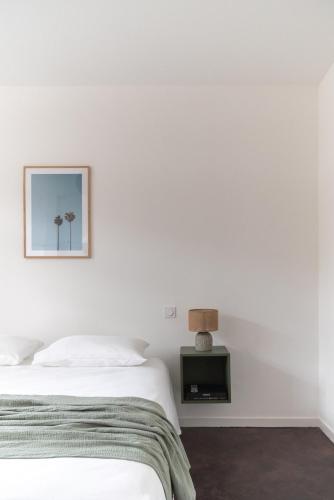 une chambre blanche avec un lit et une table dans l'établissement Palais Notre Dame des Pins - Beach and Croisette, à Cannes