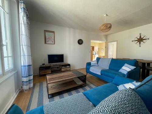 un salon avec un canapé bleu et une télévision dans l'établissement Fouras La Grande Plage, à Fouras