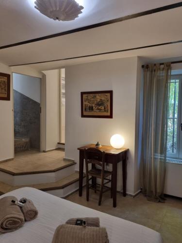 a bedroom with a desk and a table with a chair at Mas de la Petite Jeanne in Grimaud