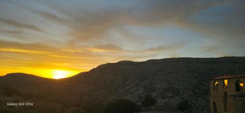 a view of the sun setting over a mountain at Dana historic village in Dana