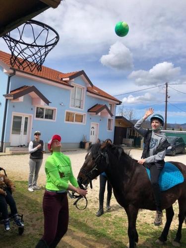 a woman playing with a girl on a horse with a ball at The Countryside Retreat in Rankovce