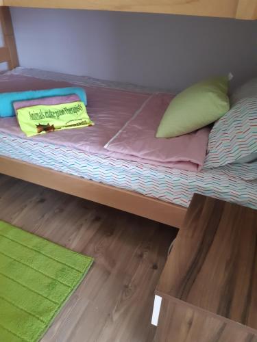 a bed with a yellow pillow and pillows on it at The Countryside Retreat in Rankovce