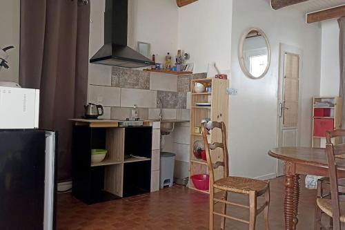 eine Küche mit Tisch und ein Esszimmer in der Unterkunft Studio privé - maison de village in Valensole