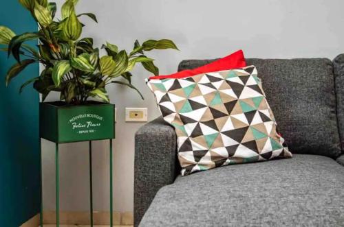 a couch with a pillow and a plant on it at Beach Life Apartments in Jan Thiel