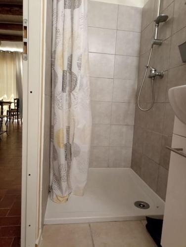 La salle de bains est pourvue d'une douche avec un rideau de douche blanc. dans l'établissement Studio privé - maison de village, à Valensole