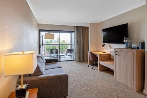 a hotel room with a couch and a bed and a television at Best Western Plus Inn at the Vines in Napa