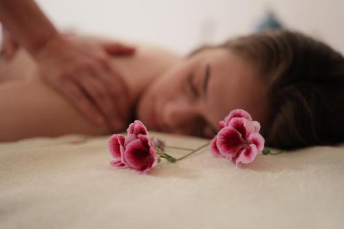 a woman laying on a bed with pink flowers at Root Redrock Yalıkavak in Yalıkavak