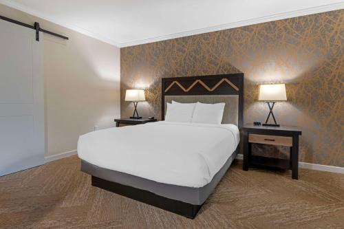 a bedroom with a large white bed and two lamps at Best Western Plus Inn at the Vines in Napa