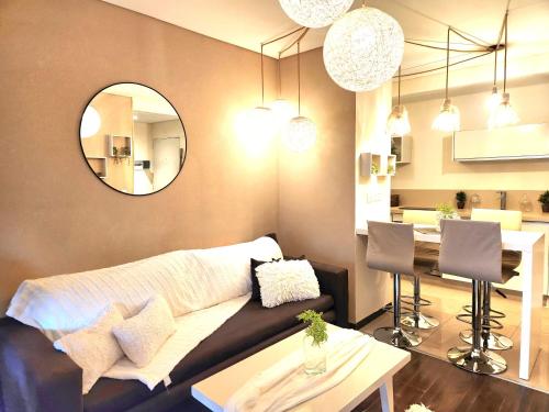 ein Wohnzimmer mit Sofa, Tisch und Spiegel in der Unterkunft Petit Lacroze in Buenos Aires