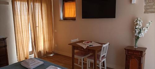 a room with a small table and a television on the wall at Villa Vinci in Recanati