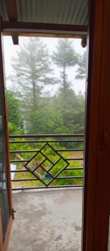 an open door to a balcony with a view of trees at Pine Peak Lodges in Kālābāgh