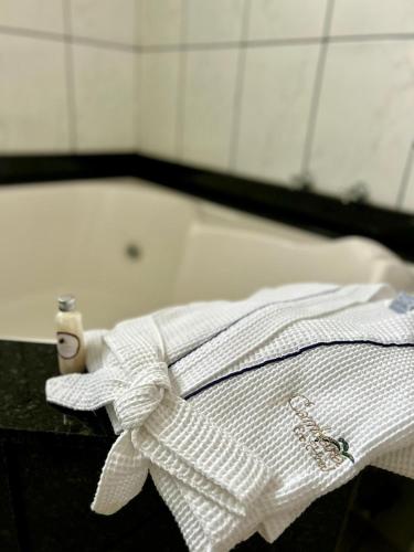 a white shirt on a table with a bath tub at Cambará Eco Hotel in Cambará