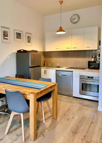 une cuisine avec une table et des chaises en bois et un comptoir dans l'établissement Joli T2 avec cachet La plaine Cours Julien, à Marseille