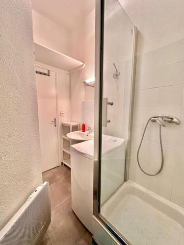 une salle de bain blanche avec une douche et un lavabo dans l'établissement Joli T2 avec cachet La plaine Cours Julien, à Marseille