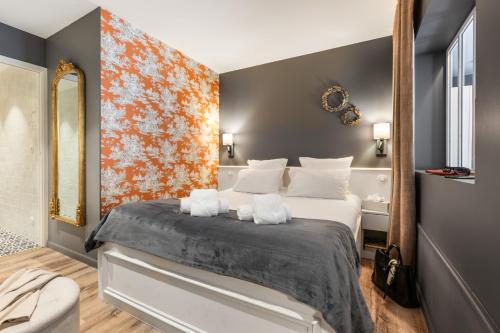 a bedroom with a large bed with white pillows at Résidences Alticimes in Brides-les-Bains