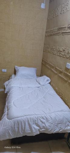 a white bed in a room with a wall at Dana historic village in Dana