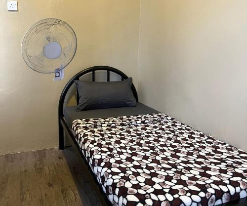 a bed in a room with a fan at Ghazrins Garuda Hotel in Johor Bahru