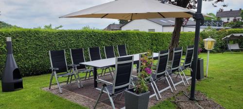 a table and chairs under an umbrella in a yard at Villa Althaus in Medebach