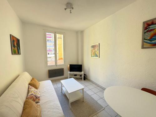 un salon avec un canapé blanc et une table dans l'établissement Nice Magnan - 3 pièces proche mer, à Nice