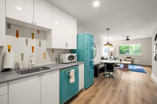 a kitchen with white cabinets and a blue refrigerator at SoCo-a-Go-Go in Austin
