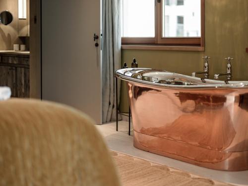 a copper tub in a bathroom with a window at Chalet Cecilia inklusive Summercard by MYALPS in Obergurgl