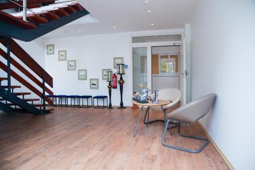 a living room with a table and chairs and stairs at Stern Hotel Hannover in Hannover