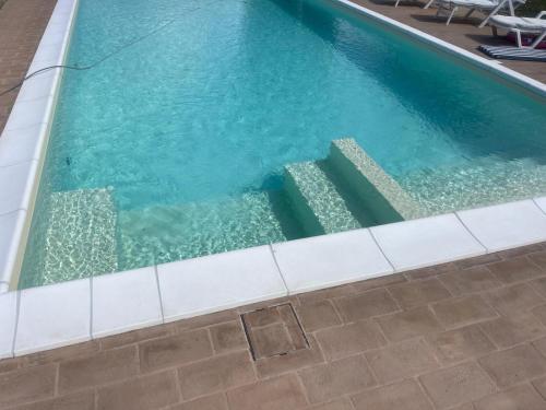 a swimming pool with stairs in the water at Villa Vinci in Recanati