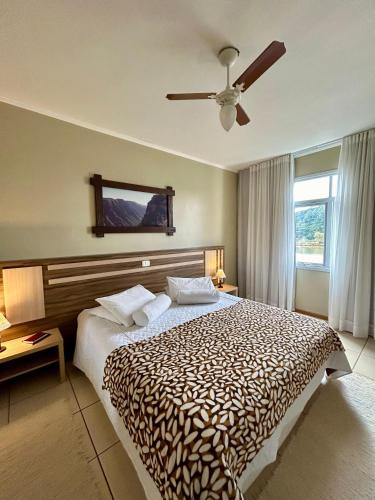 a bedroom with a bed and a ceiling fan at Cambará Eco Hotel in Cambará