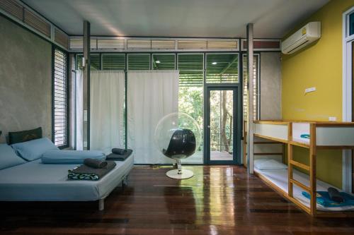 a living room with a couch and a bed and a desk at Sometimes Khaoyai in Ban Muak Lek Nai