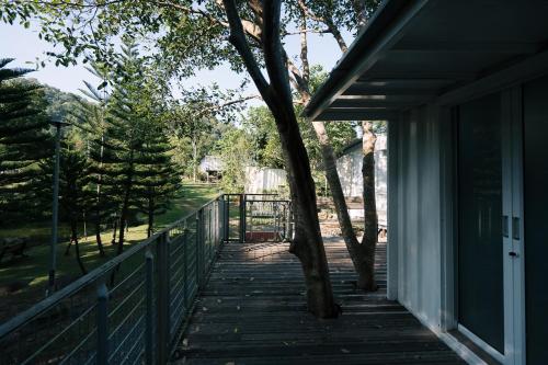 a porch of a house with a tree on it at Sometimes Khaoyai in Ban Muak Lek Nai