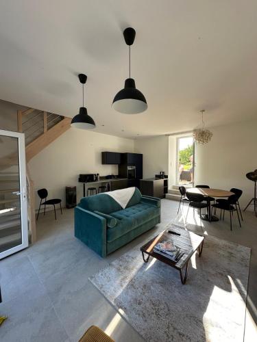 un salon avec un canapé vert et une table dans l'établissement Les Marais Blancs à Picauville, à Picauville