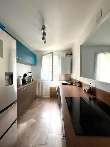 une cuisine avec parquet et armoires bleues et blanches dans l'établissement Duplex spacieux-30 min de Paris-15 min Disneyland, à Villiers-sur-Marne