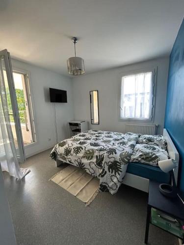 une chambre avec un lit et une télévision dans l'établissement Duplex spacieux-30 min de Paris-15 min Disneyland, à Villiers-sur-Marne